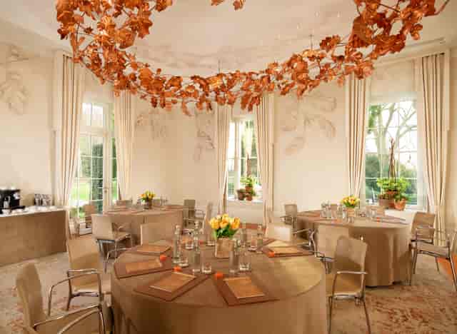 Elegant Oak Room at Coworth Park with floral centerpieces for upscale events.