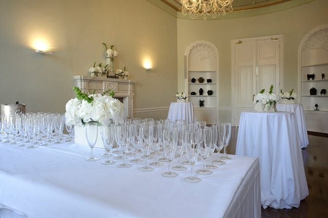 Elegant event space with white tables and floral centerpieces for upscale receptions.