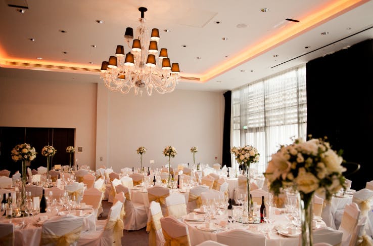 Elegant Grand Syon Ballroom with floral centerpieces, ideal for weddings and galas.