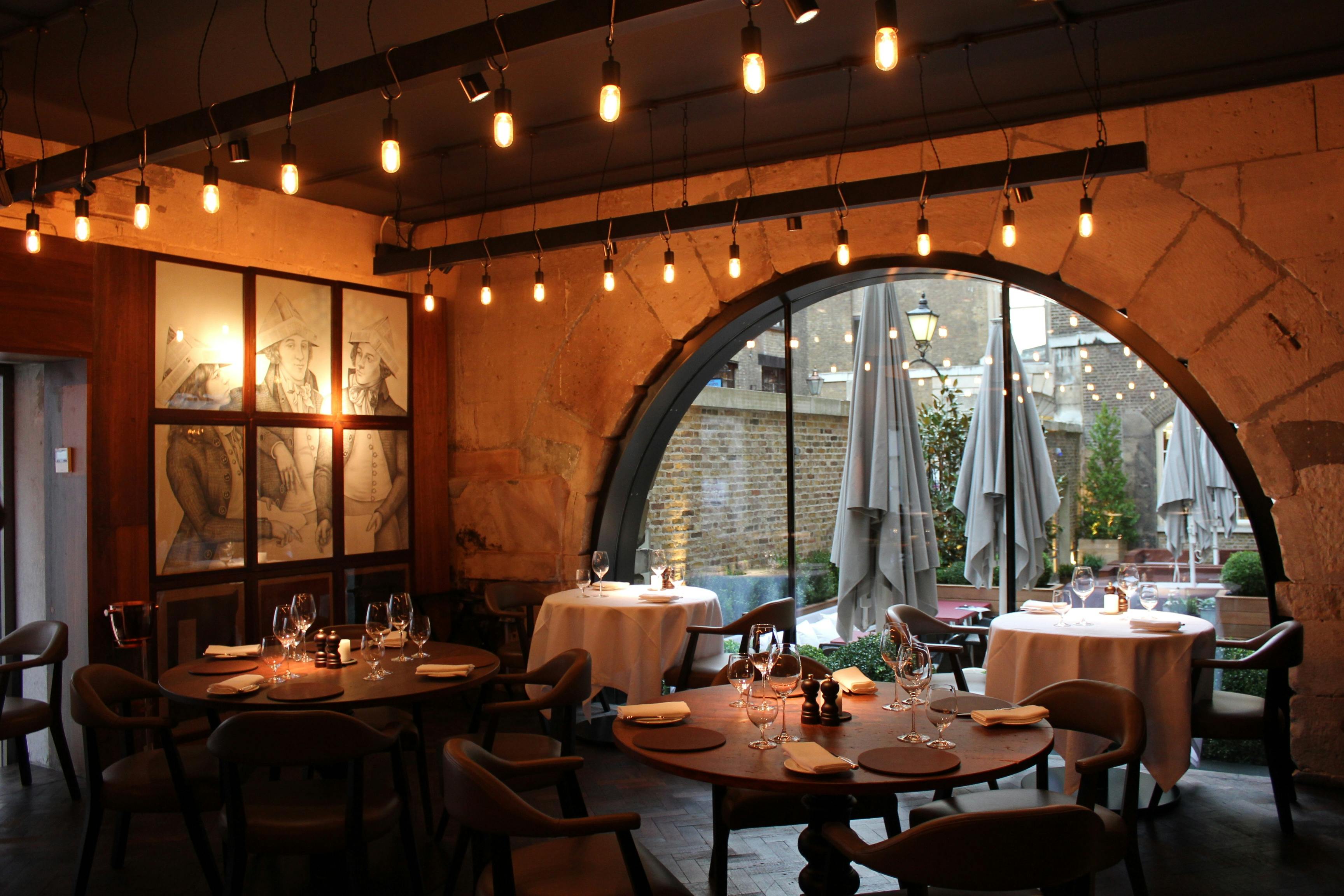 Elegant restaurant venue with arched window, ideal for corporate dinners and private events.