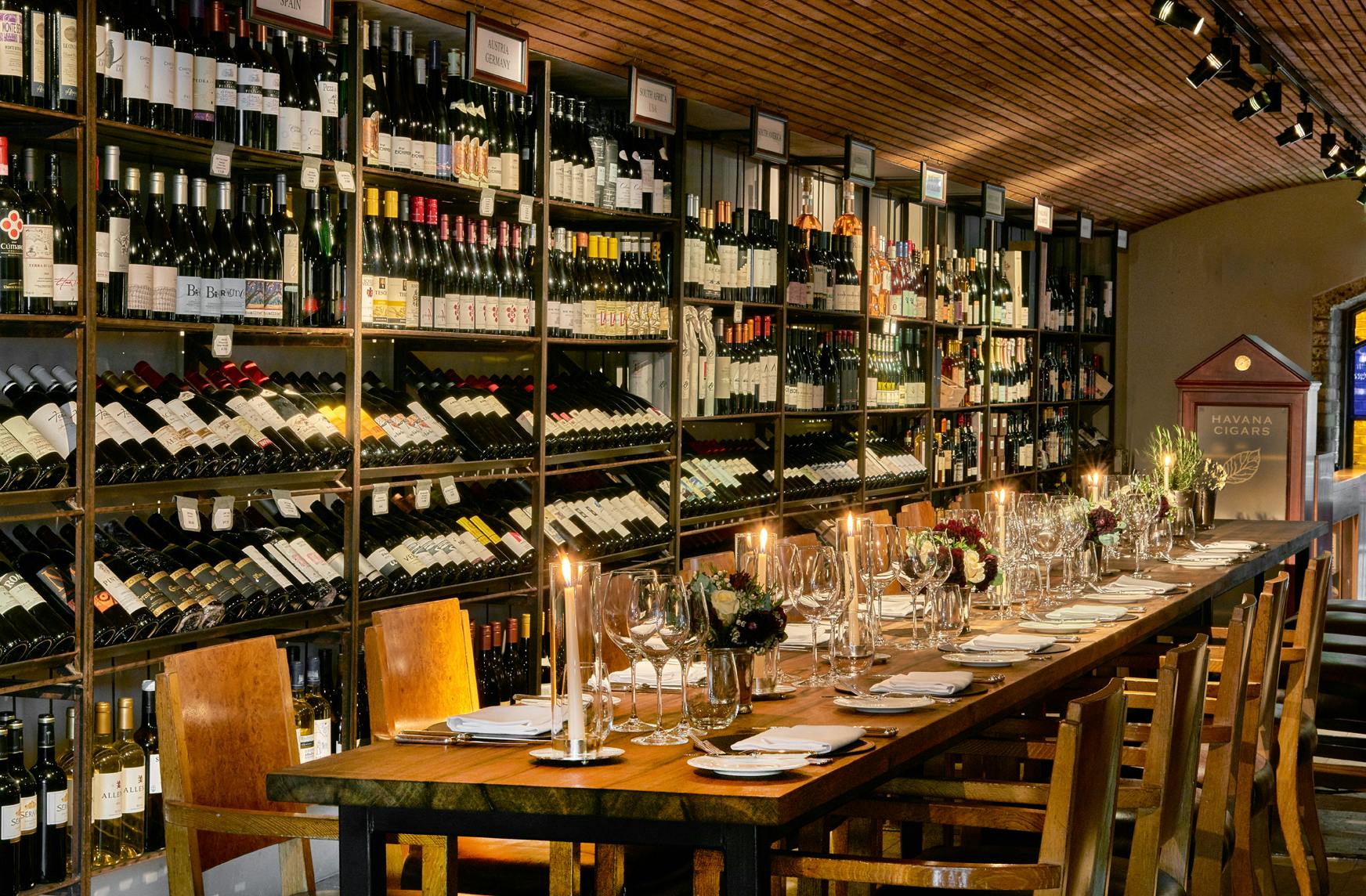 Elegant wine cellar dining space with extensive wine display for exclusive events.