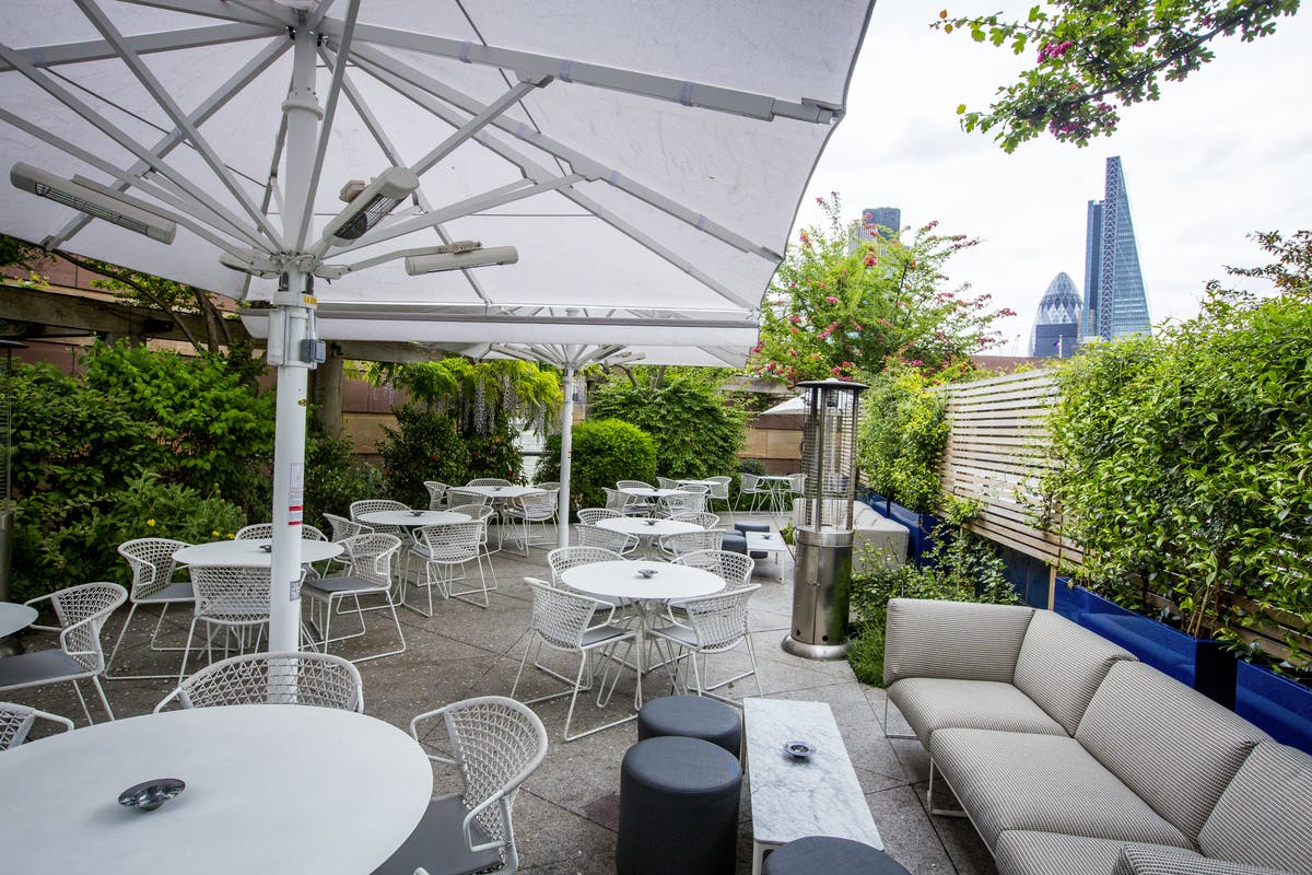 Stylish outdoor event space at Coq d'Argent with city skyline, ideal for networking receptions.