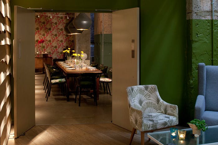 Private meeting room with green walls, ideal for gatherings and events at The Folly Bar.