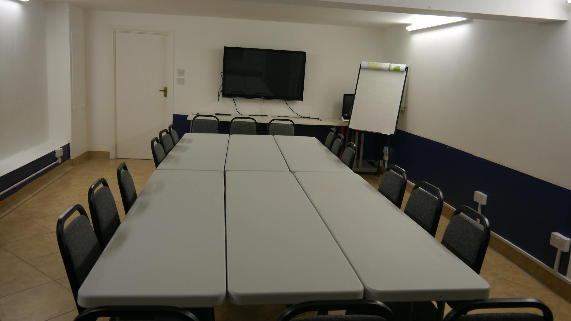 Meeting room with long table, ideal for workshops and team meetings.