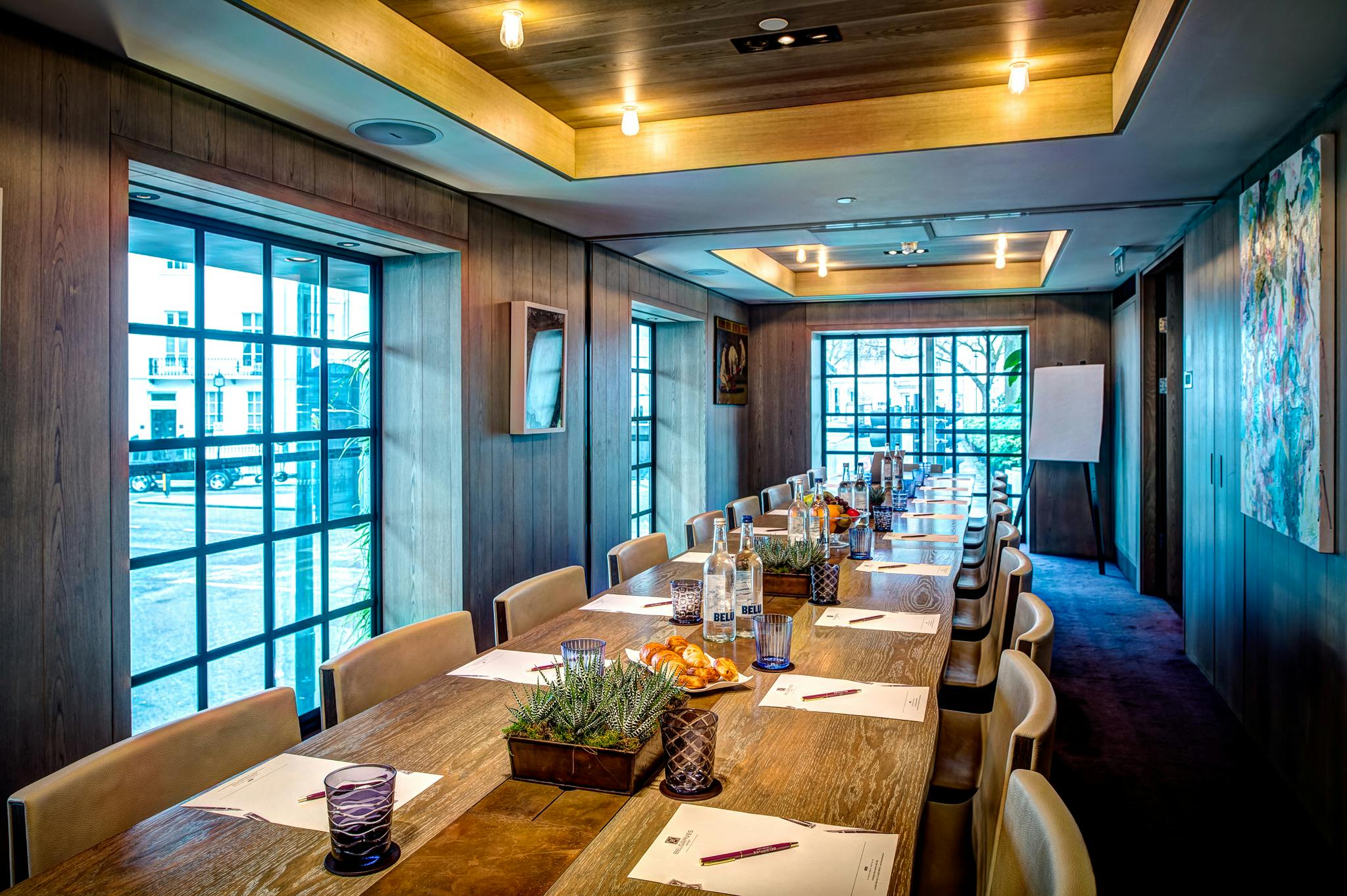 Meeting room at The Muse in The Hari with a long wooden table, ideal for collaboration.