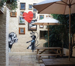 Banksy Beer Garden mural with child and lion at The Princess of Wales Pub for outdoor events.