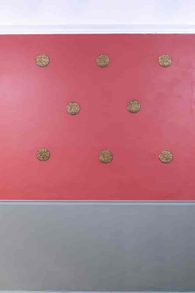 Ashbee Hall's pink wall with gold medallions, perfect for events and photo ops.