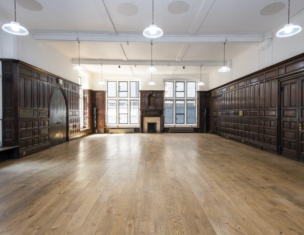 Spacious Toynbee Hall lecture room with wooden paneling for meetings and workshops.