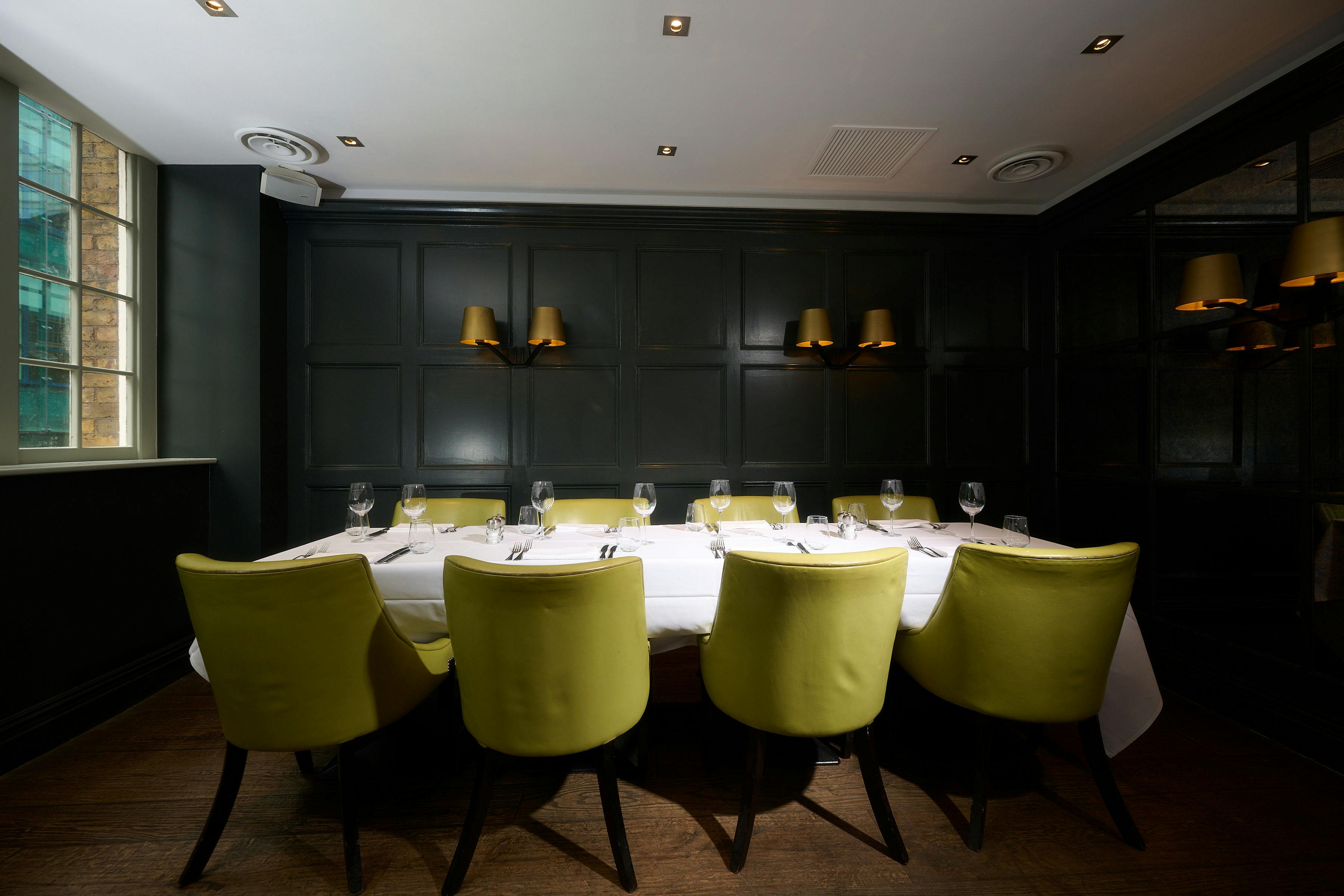 Intimate dining space with green chairs, ideal for corporate events and private meetings.