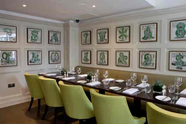 Elegant private dining room with green chairs for meetings and events in Chiswell Street.