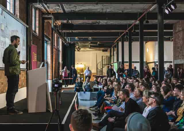 Engaging speaker at modern Paintworks Event Space during a successful event.