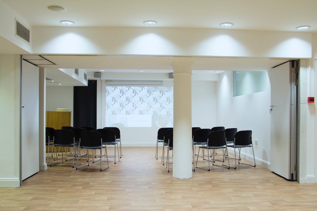 Versatile meeting space with projector screen for workshops and presentations at esea Studio.