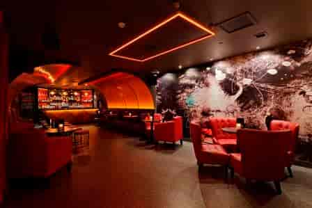 Stylish cocktail cabinet in modern venue with red seating, perfect for networking events.