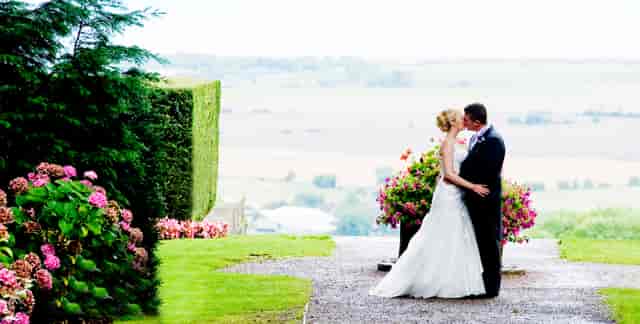 Outdoor wedding venue at Port Lympne Hotel with lush greenery and floral arrangements.