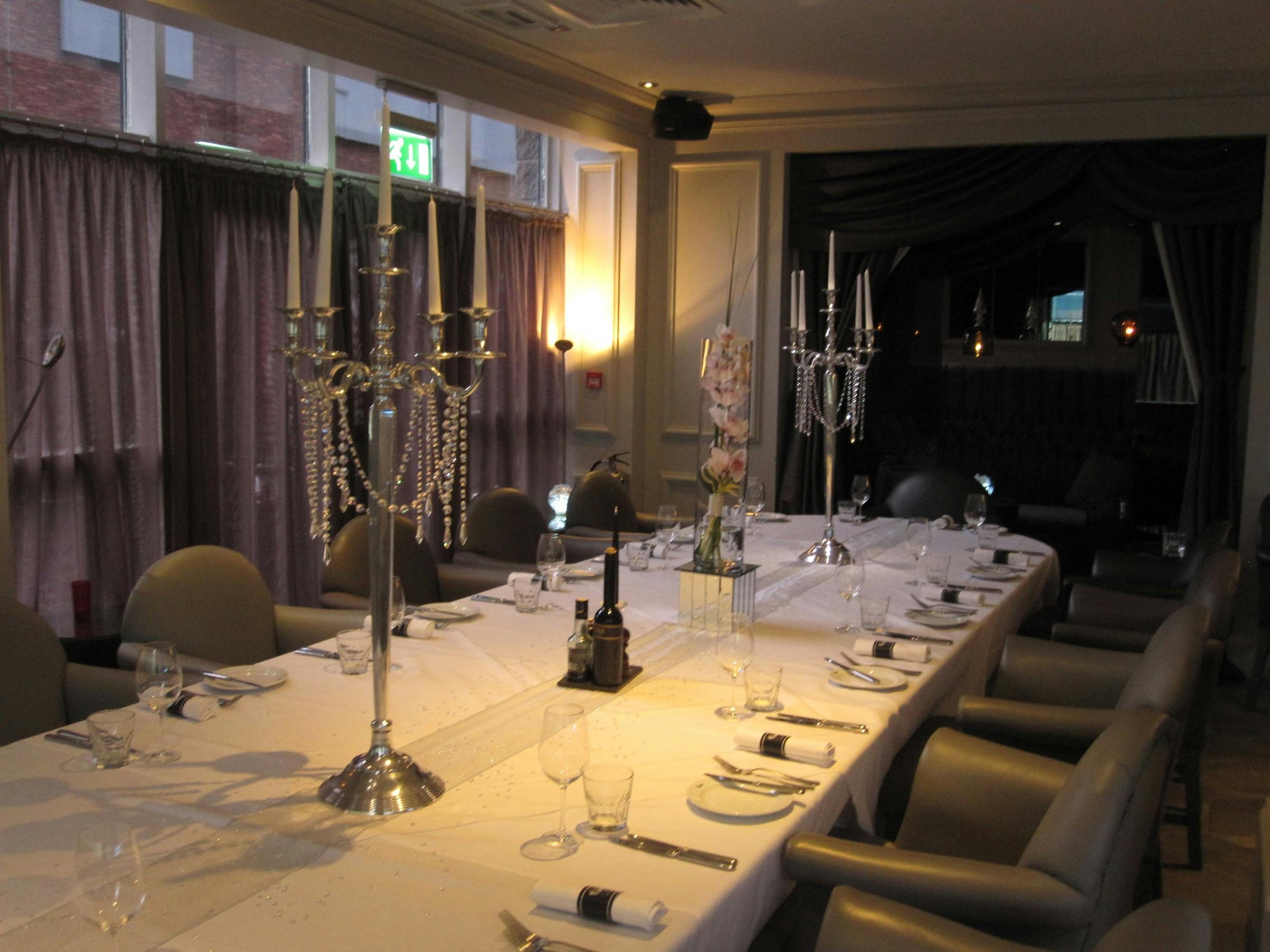 Elegant dining table with candelabras at Ember Lounge, perfect for corporate events and gatherings.