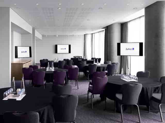 Dublin Suite at Radisson Blu: modern meeting space with round tables for corporate events.