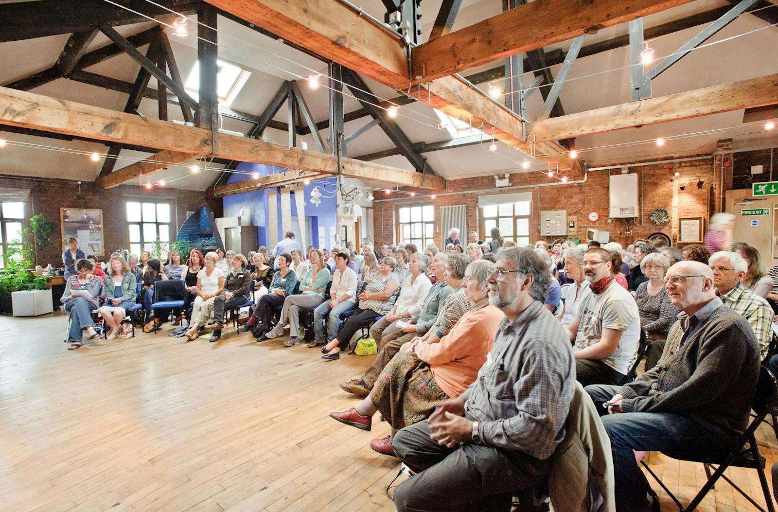 Silk Loft event with engaged audience in rustic venue, perfect for networking and presentations.