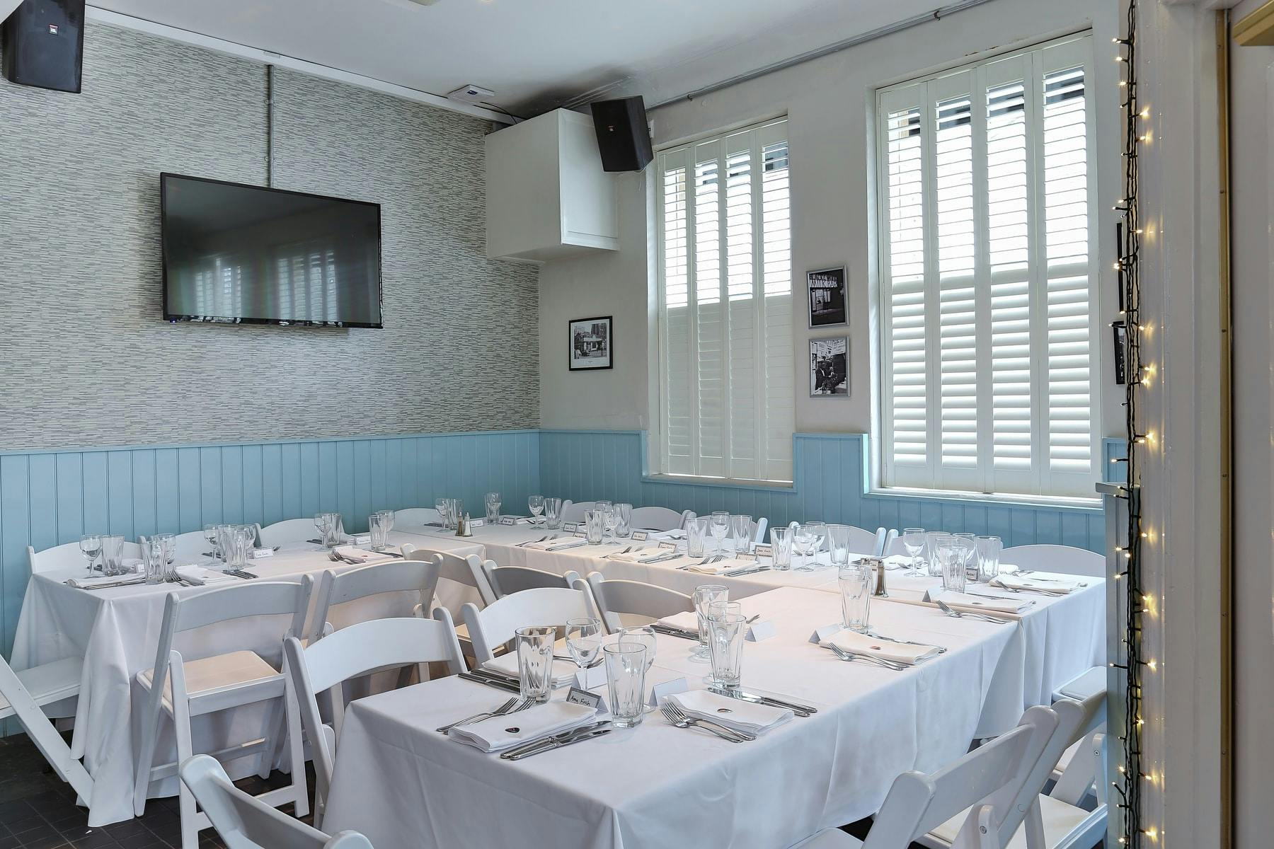 Elegant meeting space with white tablecloths, ideal for corporate events and gatherings.