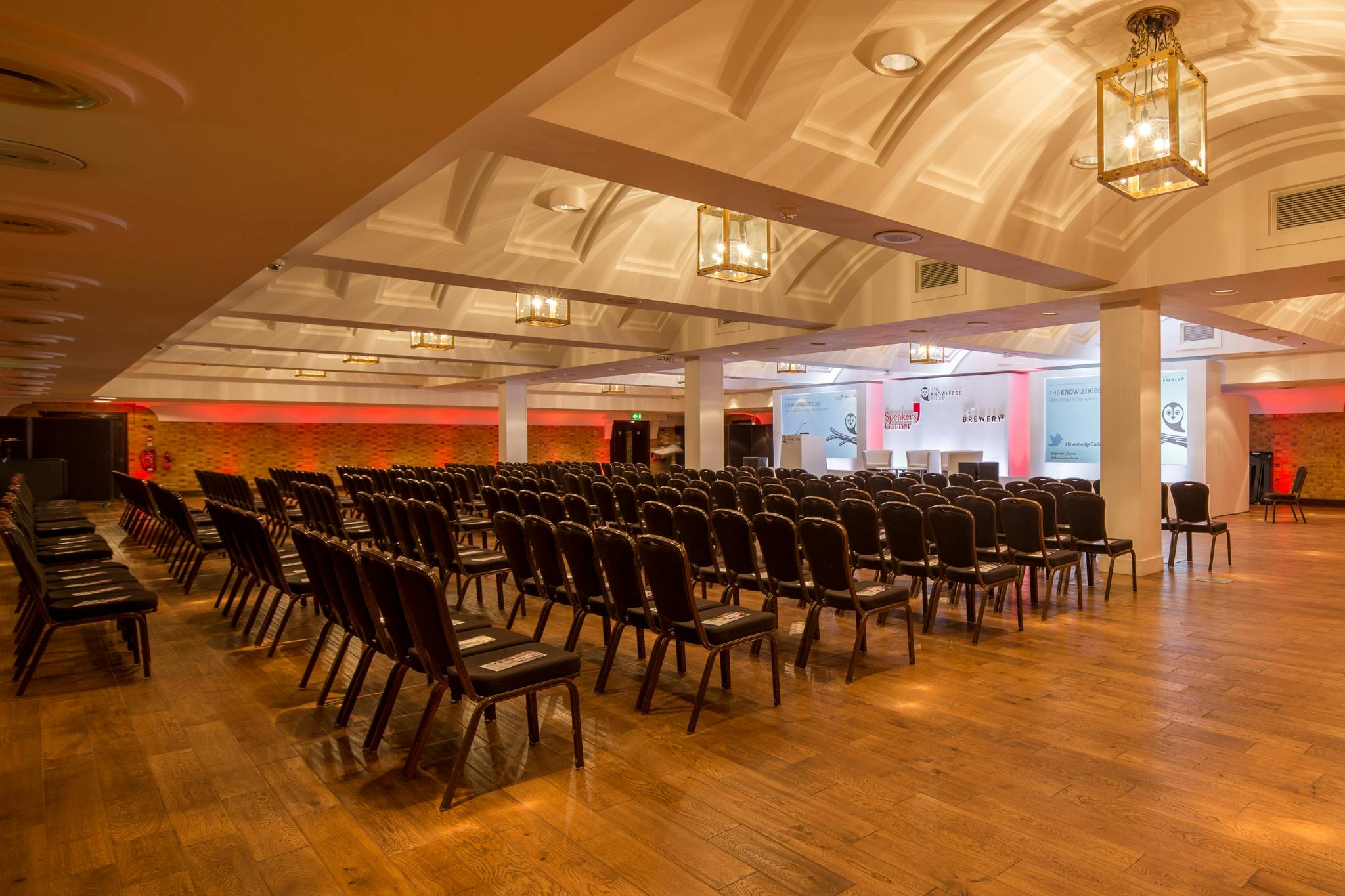 Spacious conference venue with black chairs and elegant decor at The King George III.
