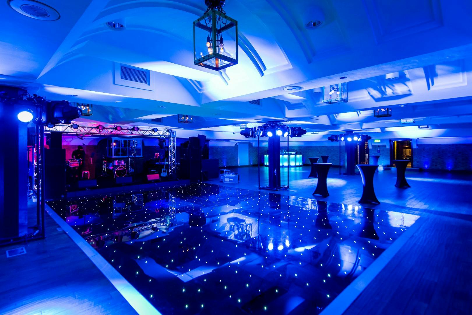 Stylish event space with dance floor and twinkling lights for corporate events and celebrations.