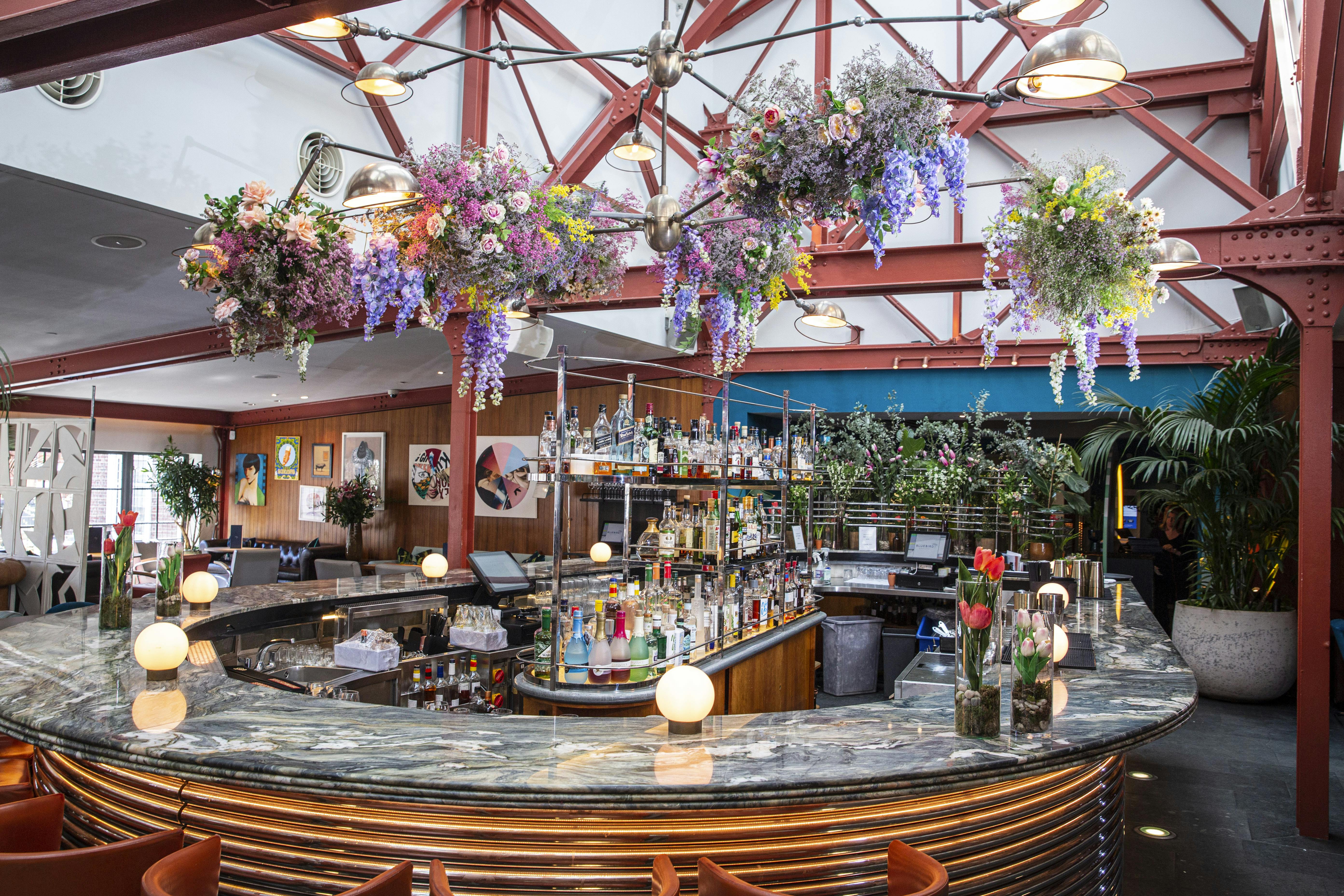Vibrant Bluebird Chelsea restaurant with floral decor, ideal for events and gatherings.