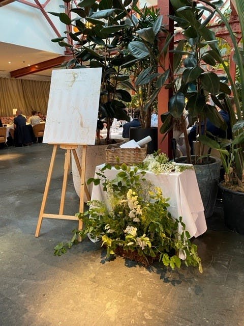 Elegant event space at Bluebird Chelsea with fresh flowers and a blank easel.