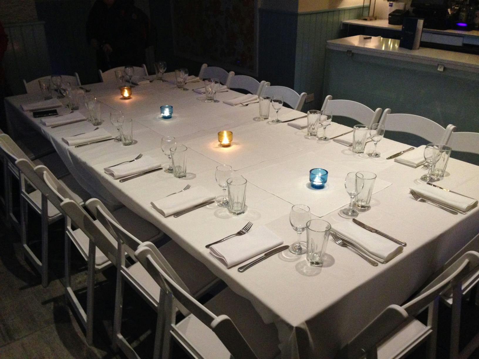 Intimate dining setup with white linens in The Terrace Room, ideal for meetings and gatherings.