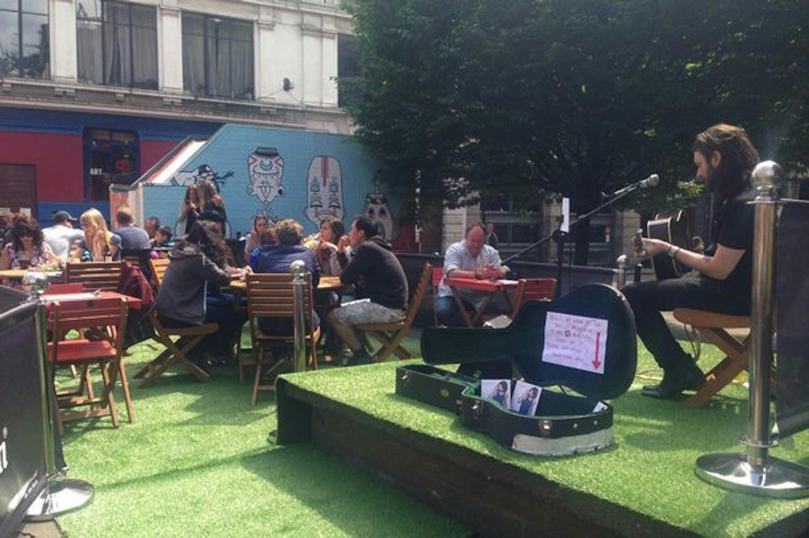 Vibrant outdoor event space with seating and greenery for gatherings in Tib Street Garden.