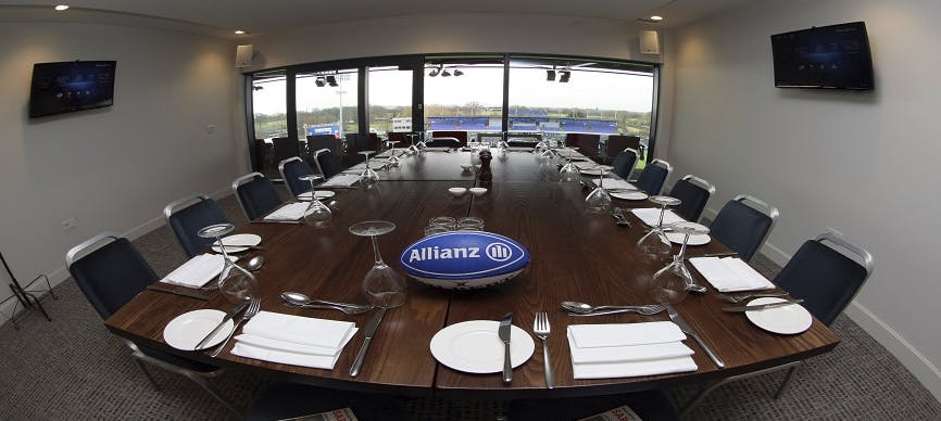 Executive Boxes at StoneX Stadium, polished wooden table set for corporate events.