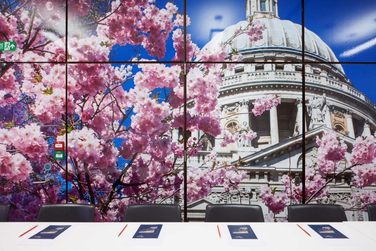 Modern boardroom with cherry blossoms backdrop, ideal for corporate meetings and presentations.