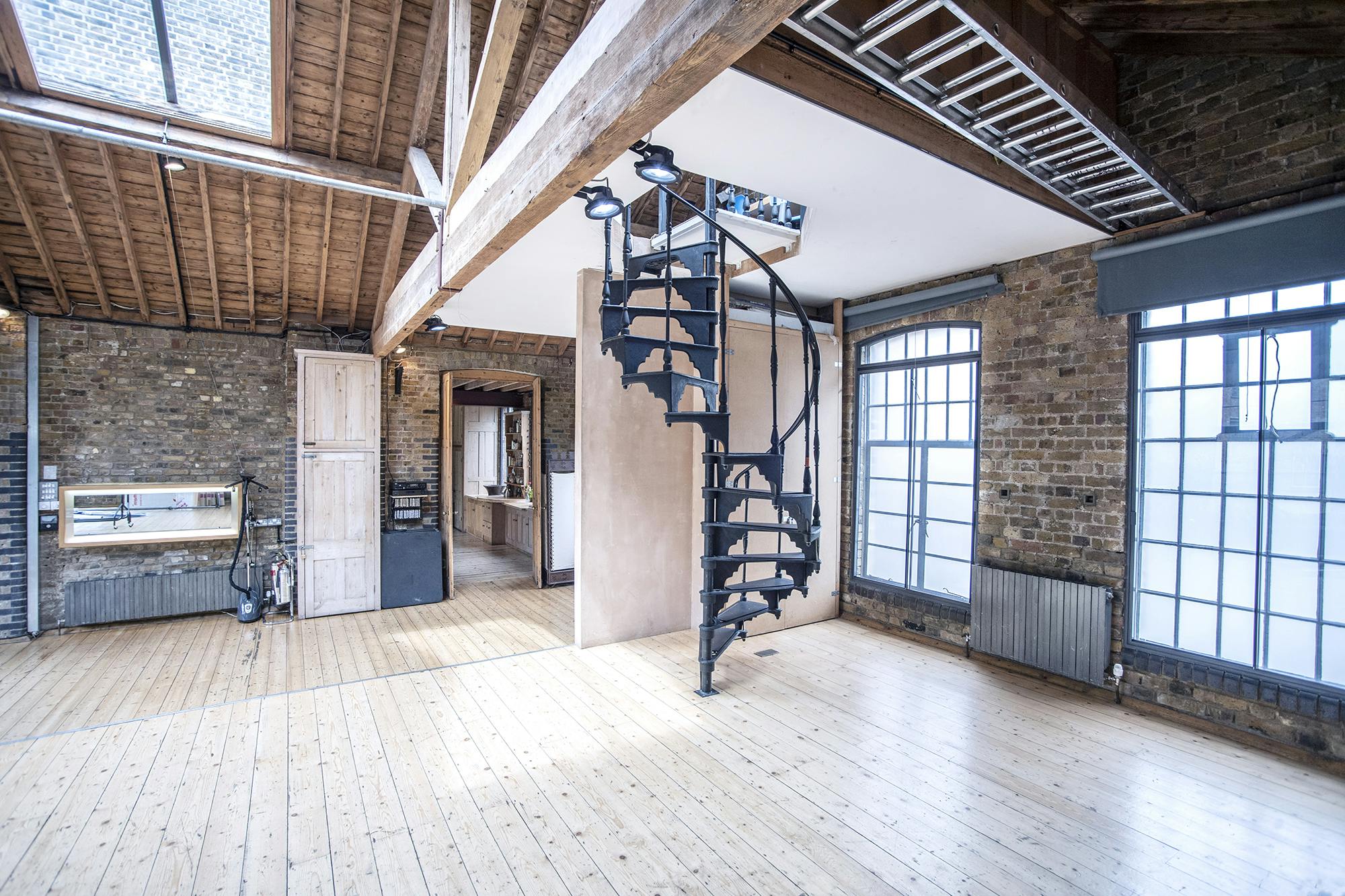 Versatile event space with exposed brick walls and natural light for corporate meetings.