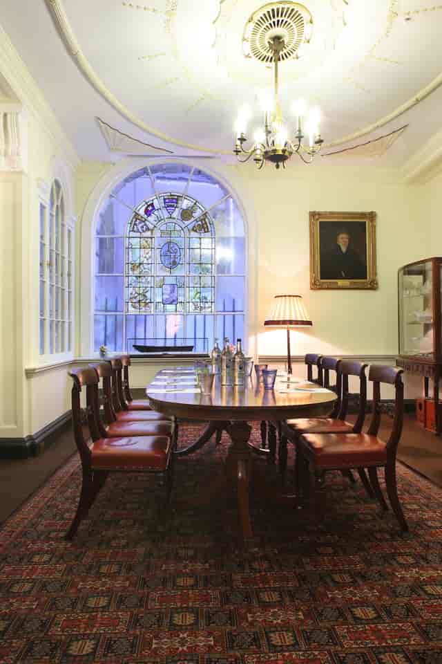 Sophisticated Parlour Room with polished table, stained glass for meetings and gatherings.