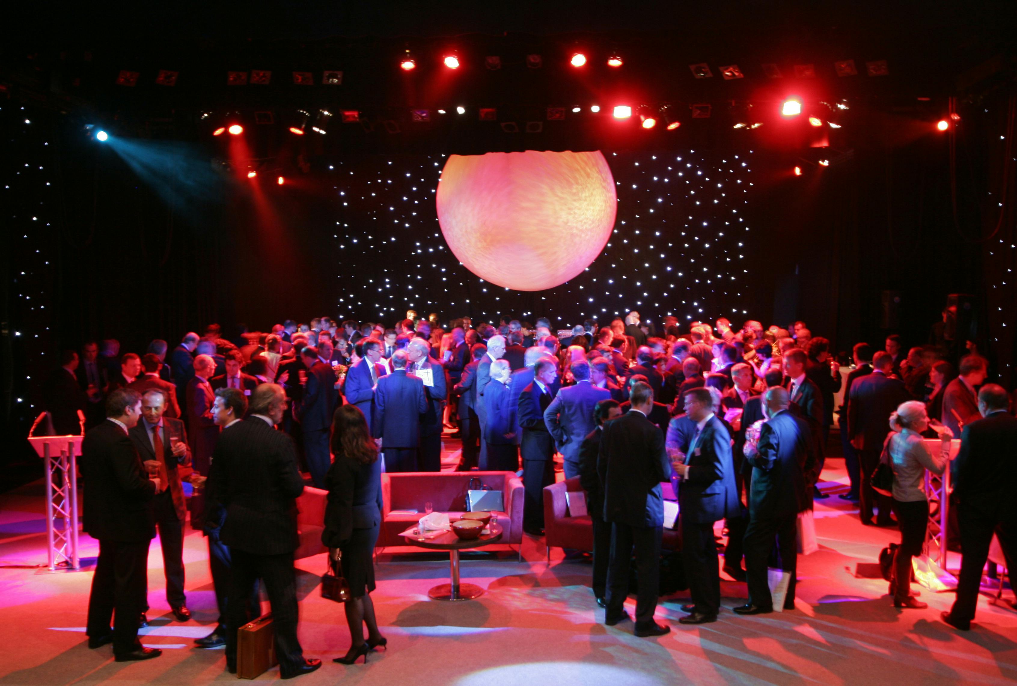 Vibrant networking event in The Mermaid London with dramatic lighting and stylish decor.