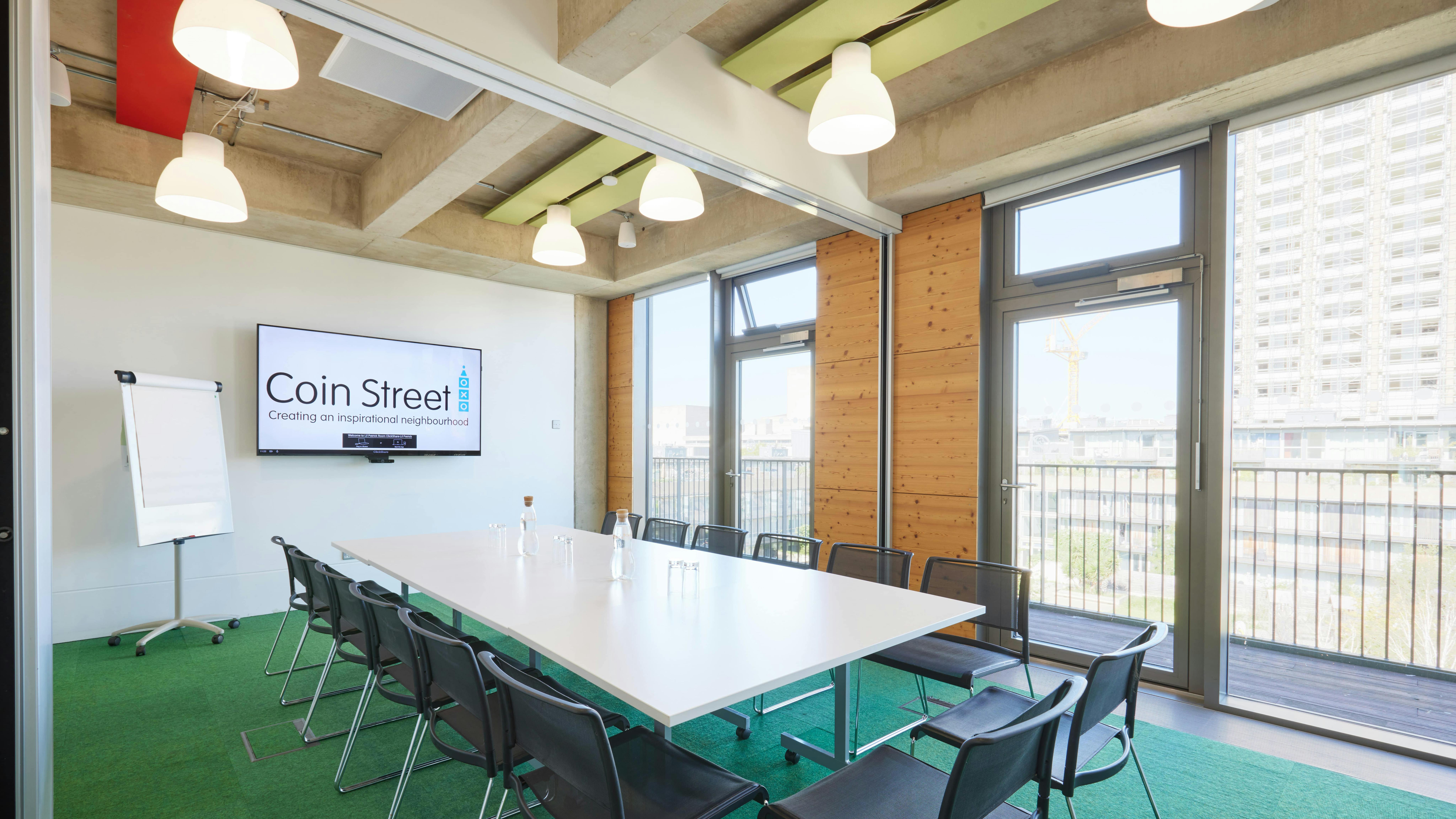 Modern meeting room with large white table, ideal for conferences and events.