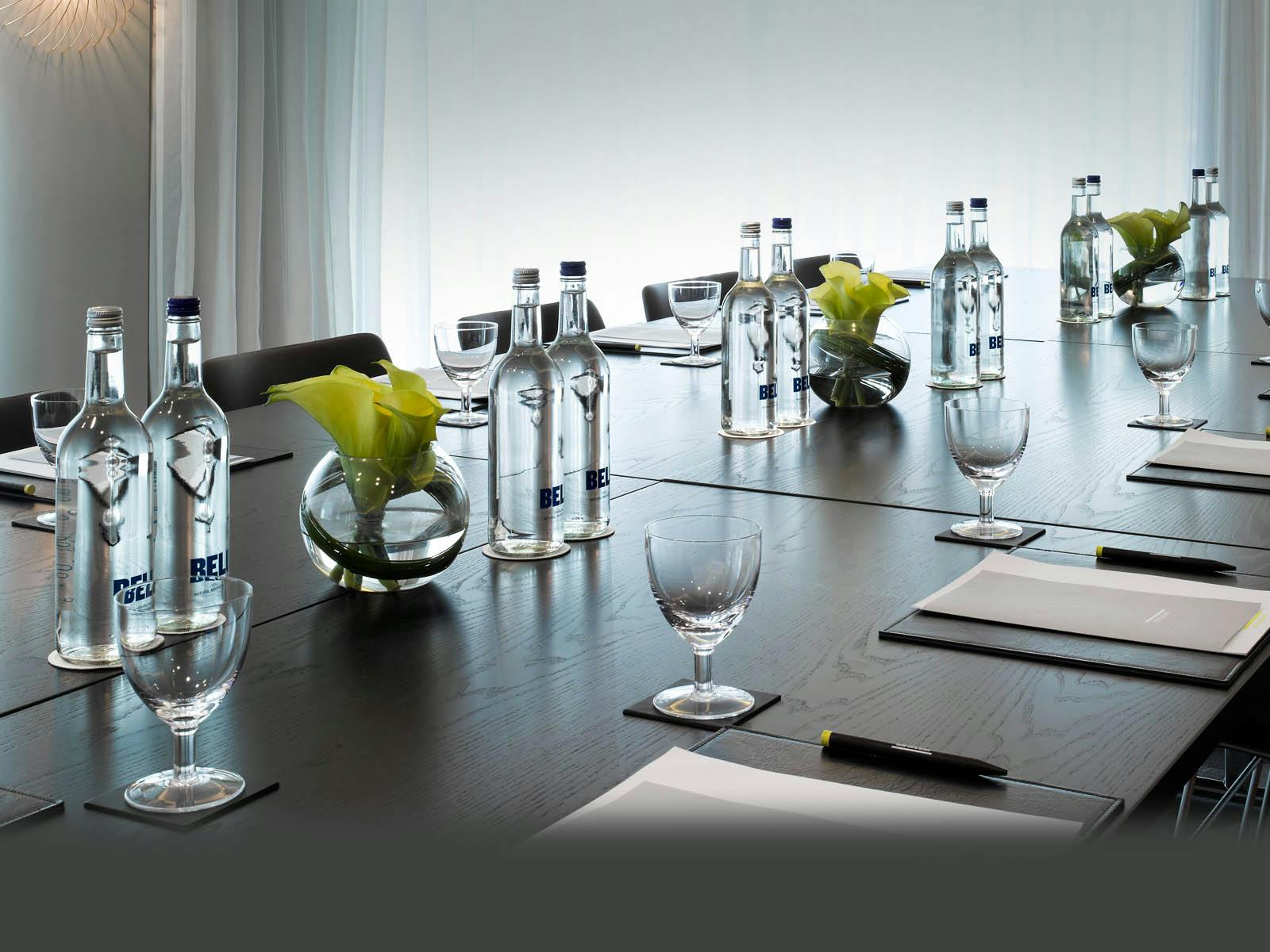 Elegant meeting room at South Place Hotel with wooden table and floral centerpieces.