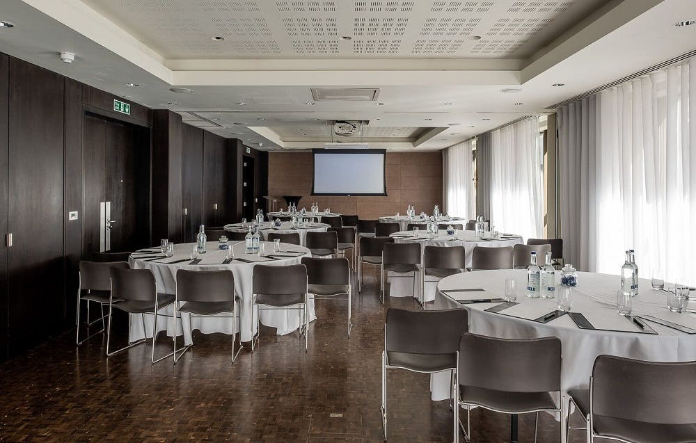 Meeting room at South Place Hotel with round tables, ideal for conferences and workshops.