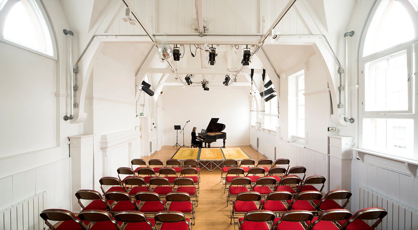 Theatre Showroom with grand piano, ideal for intimate performances and workshops.