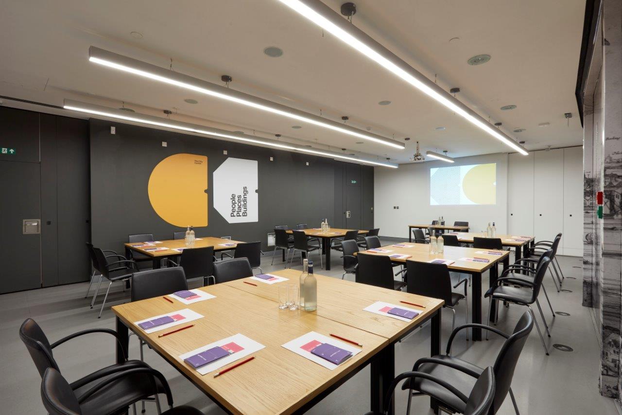 Modern conference suite with tables for group discussions, ideal for workshops and presentations. - Banner
