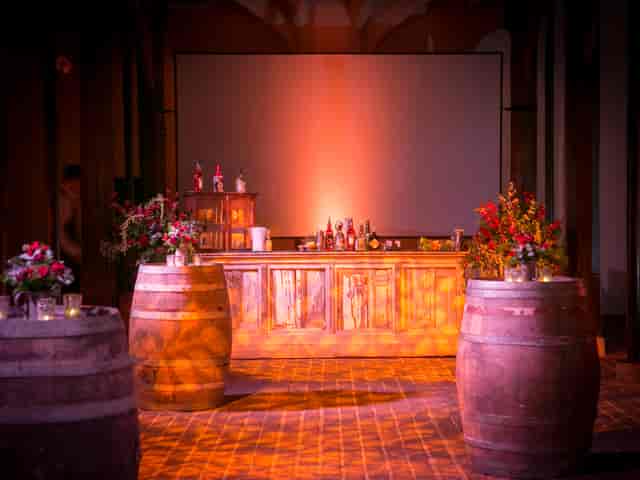 Hampton Court Palace event space with rustic bar and floral decor, ideal for gatherings.