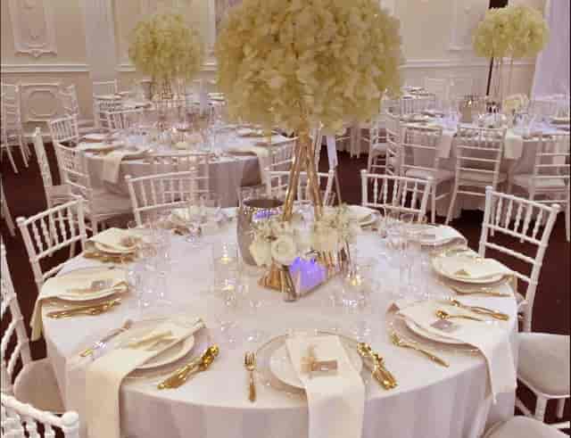 Elegant wedding reception at Boleyn Banqueting Suite featuring gold-rimmed plates and florals.