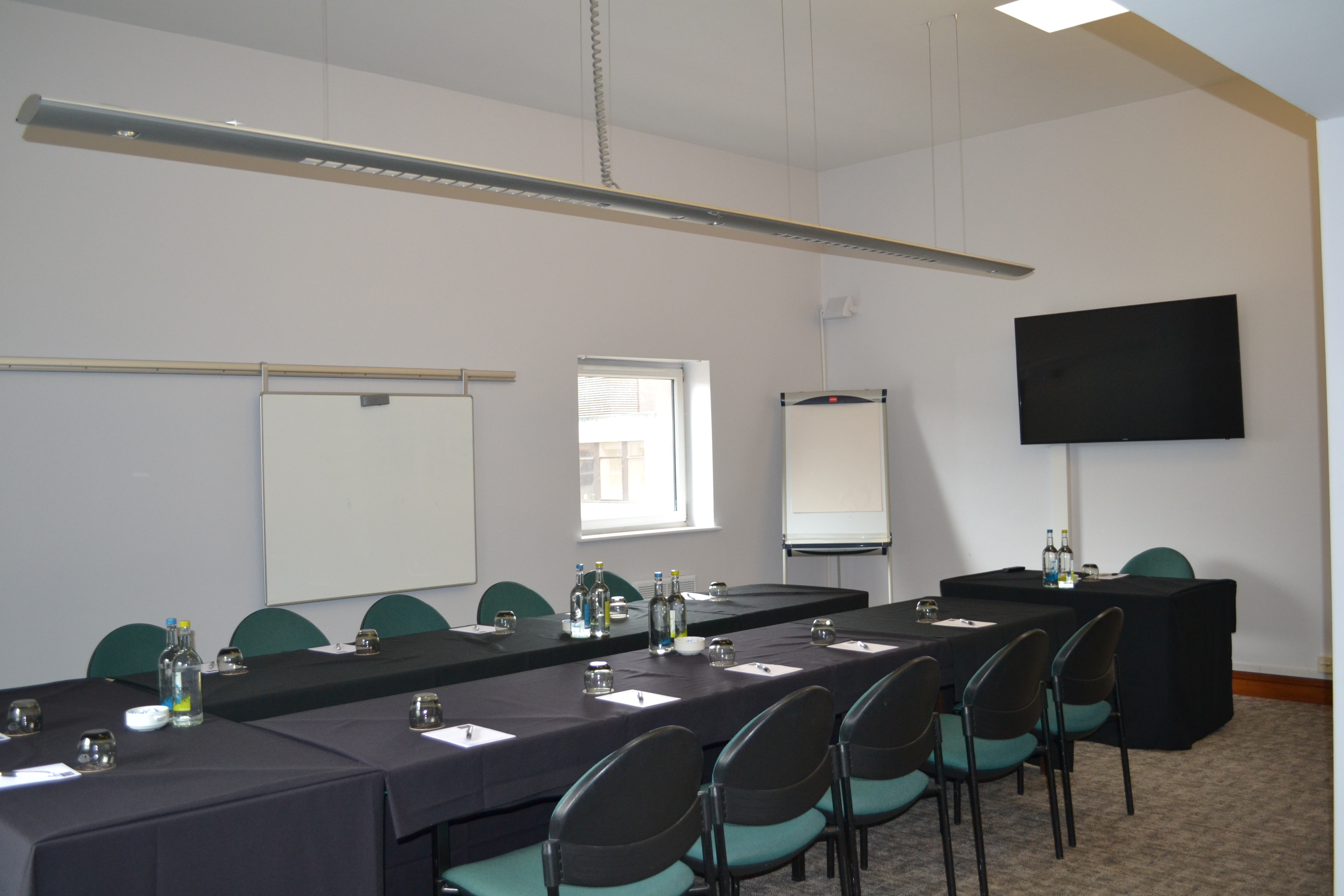Adamson Suite meeting room with long table, ideal for conferences and presentations. - Banner