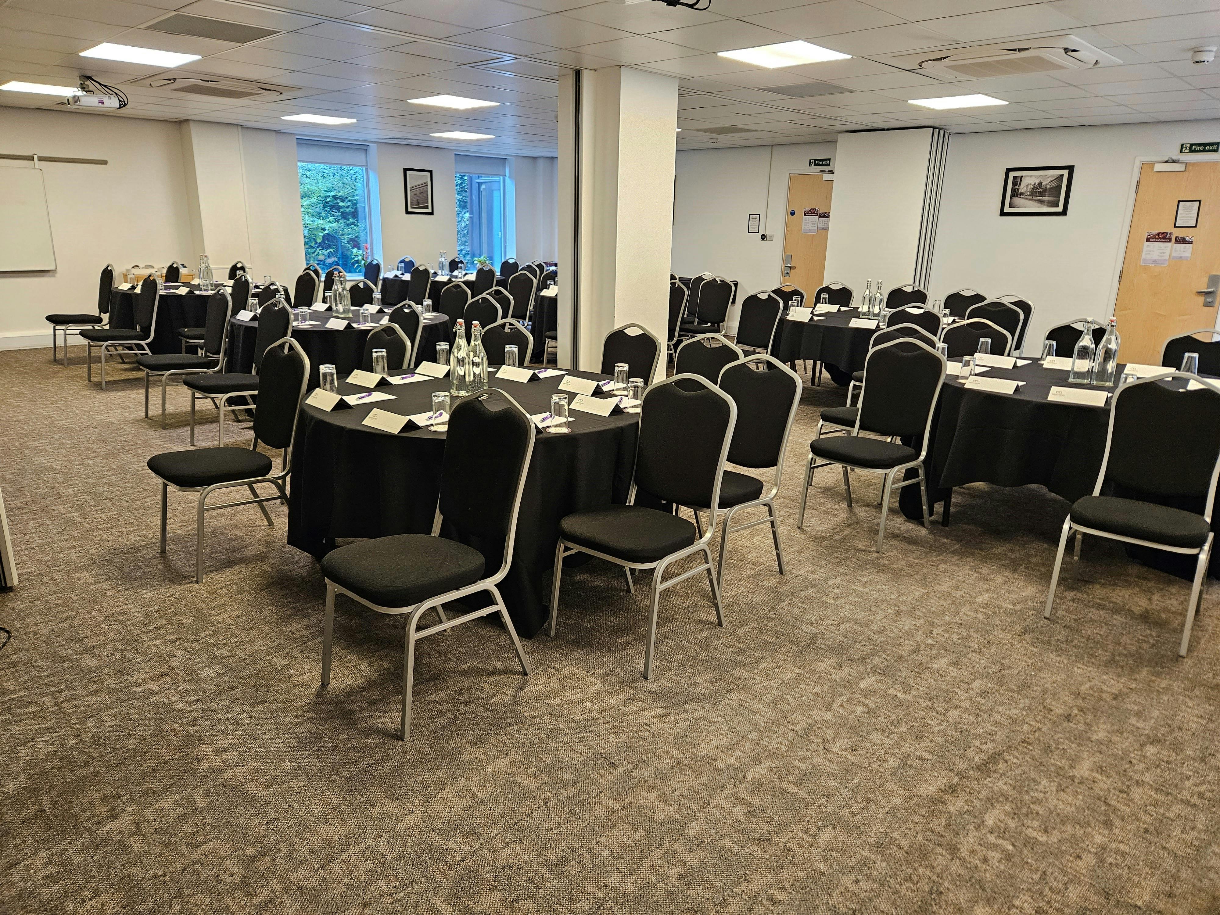 Graphene Suite meeting space with round tables, ideal for professional events in Manchester.