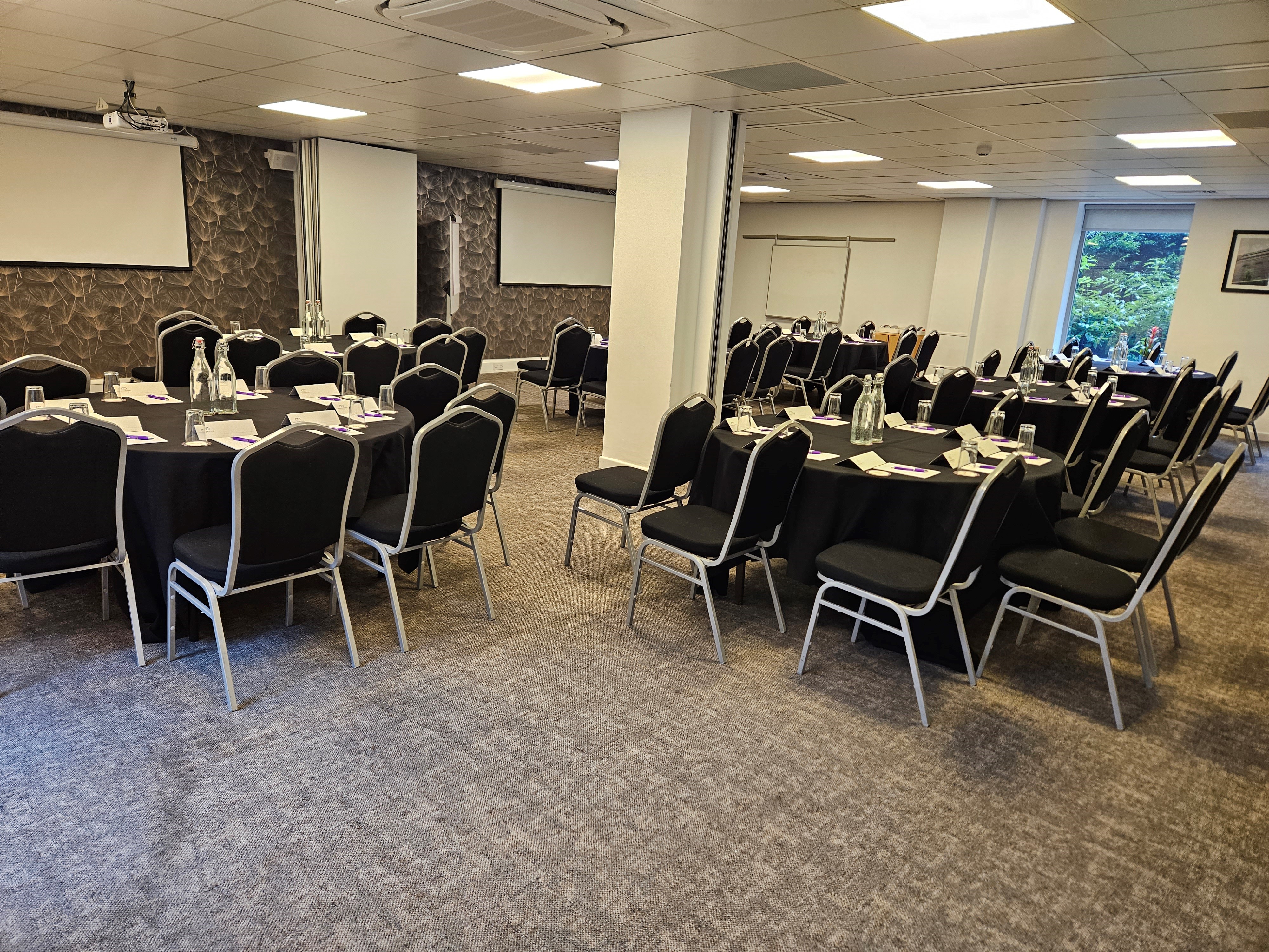 Graphene Suite meeting space with round tables, ideal for conferences and presentations.