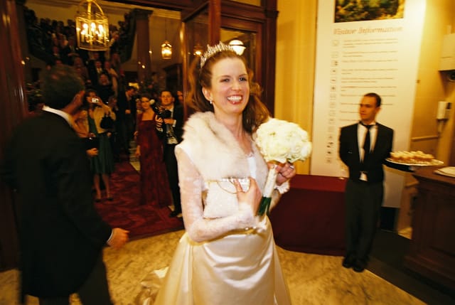 Joyful bride with bouquet in elegant wedding venue at The Wallace Collection.