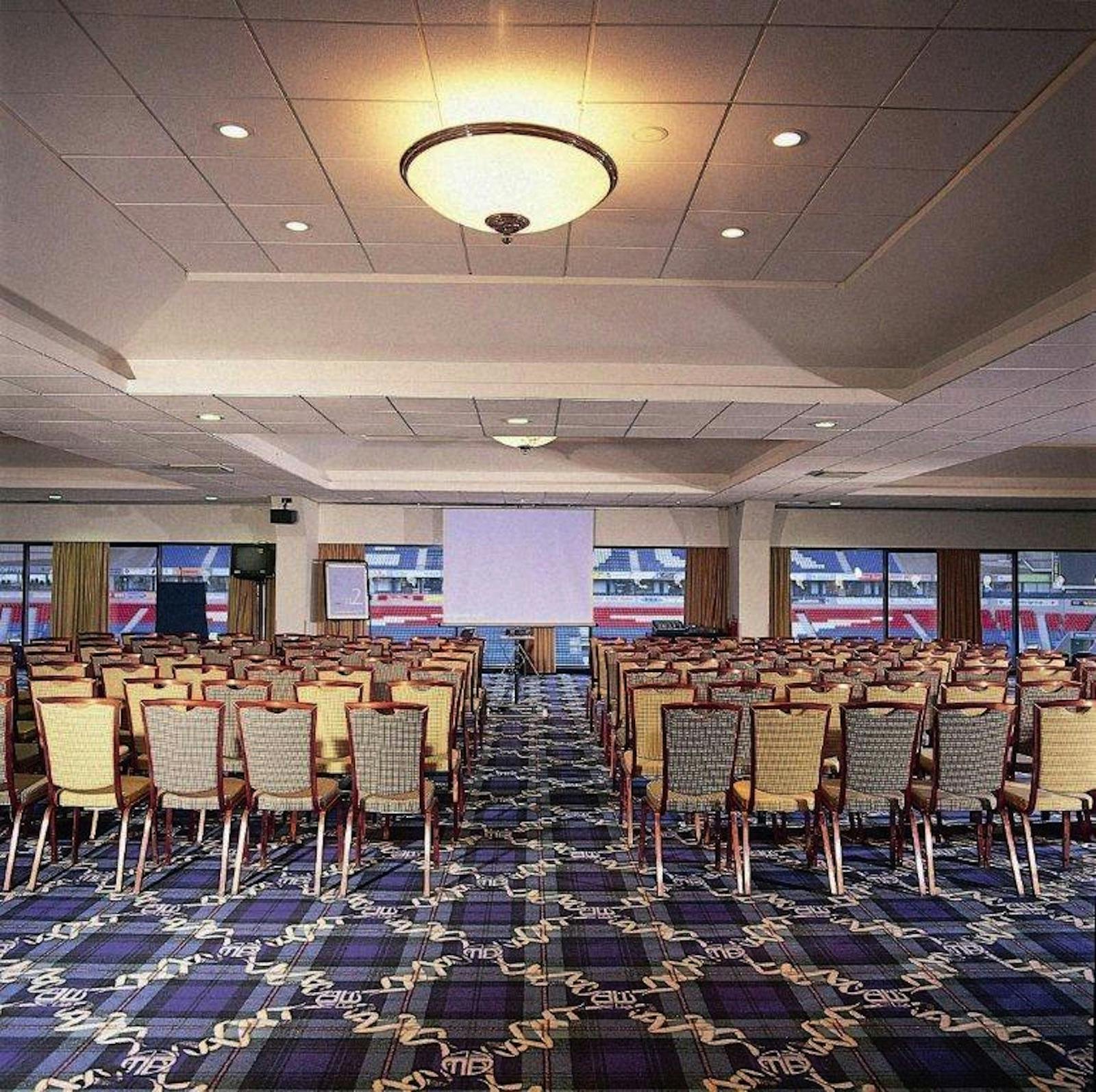 Platinum Suite at Bolton Whites Hotel, spacious conference venue with projection screen.