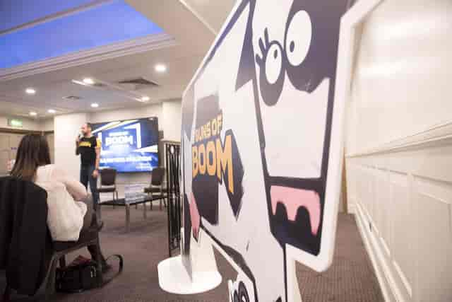 Cow-themed event setup at The James Watt, featuring a speaker and modern presentation screen.