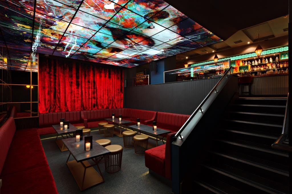 Vibrant event space at The Martini Den with striking ceiling, ideal for cocktail receptions.