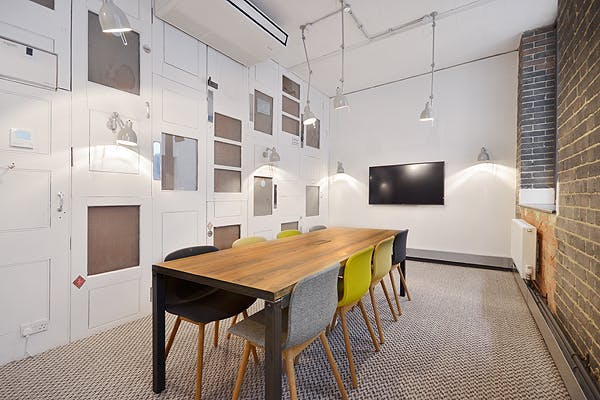 Modern meeting room with wooden table and colorful chairs for collaborative sessions.