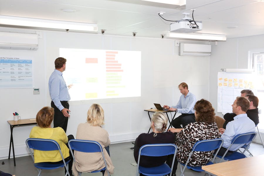 Seminar room with projector, engaging audience for effective training and collaboration.