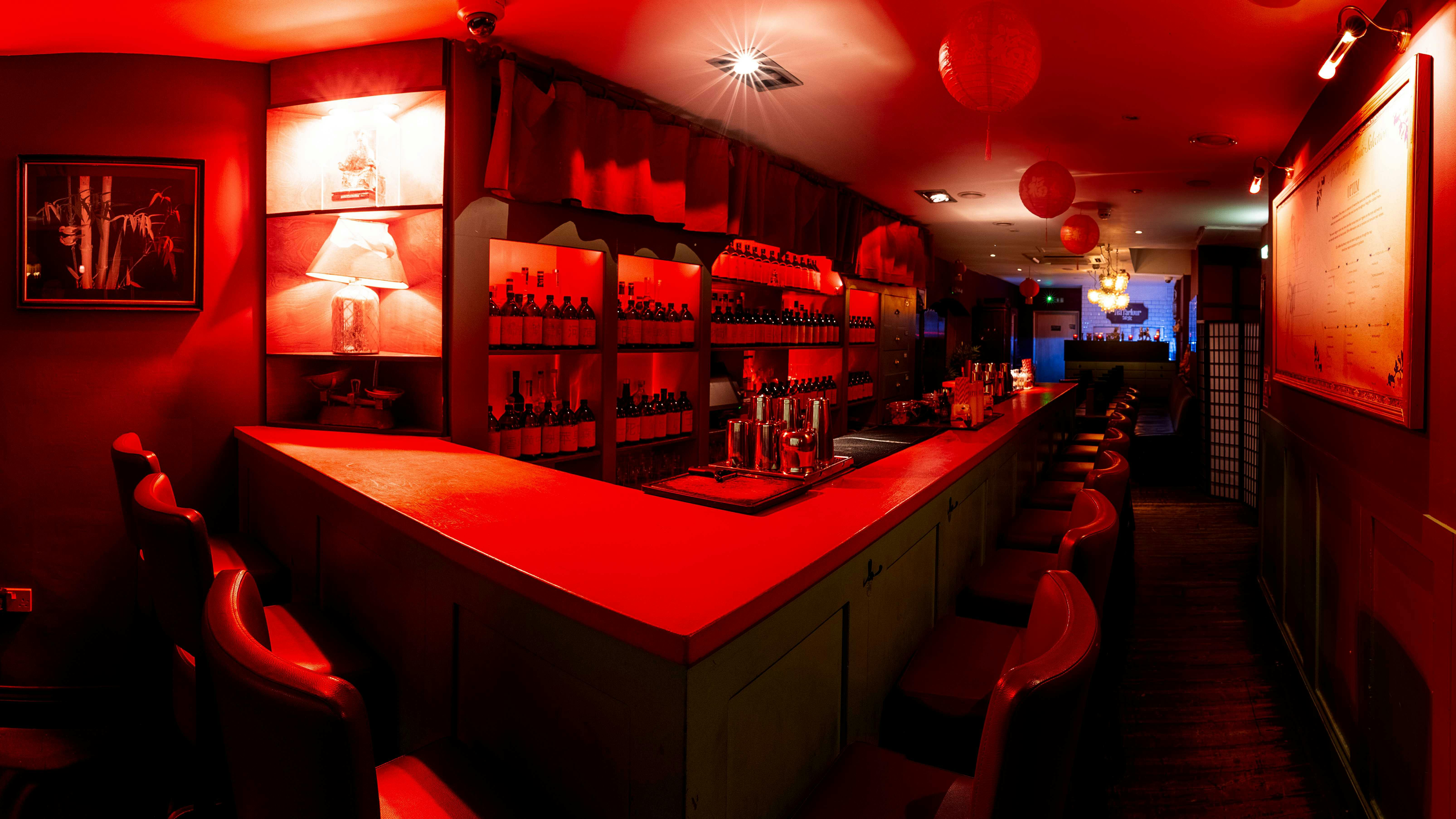 Vibrant Apothecary Bar with red ambiance, perfect for intimate gatherings and events.